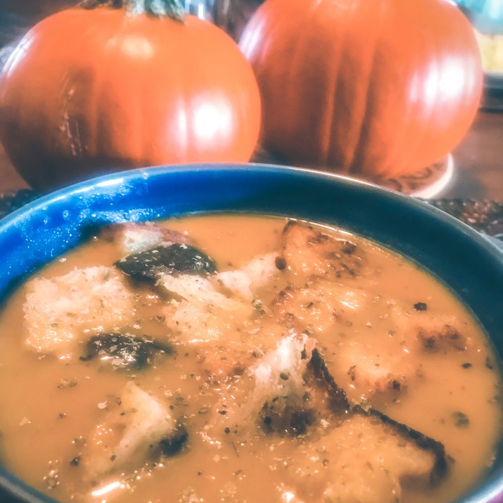 cozy fall soup with pumpkins in the background
